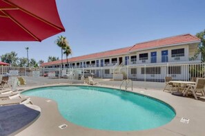 A hotel with a swimming pool, outdoor seating, and a fenced area. - 2 Full Beds | Mini Fridge (Tempe)