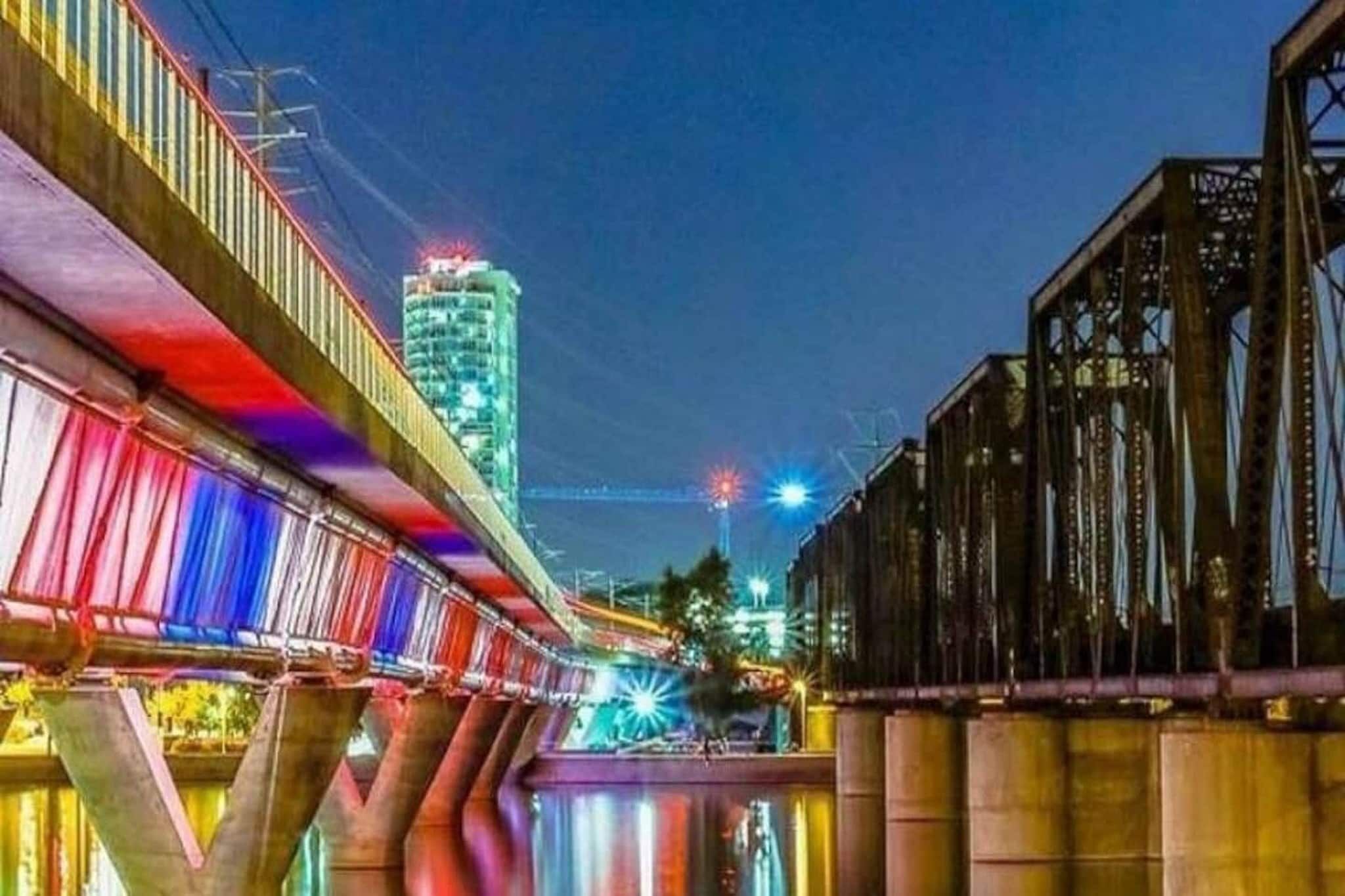 Vista nocturna de un puente con su reflejo en el agua.
