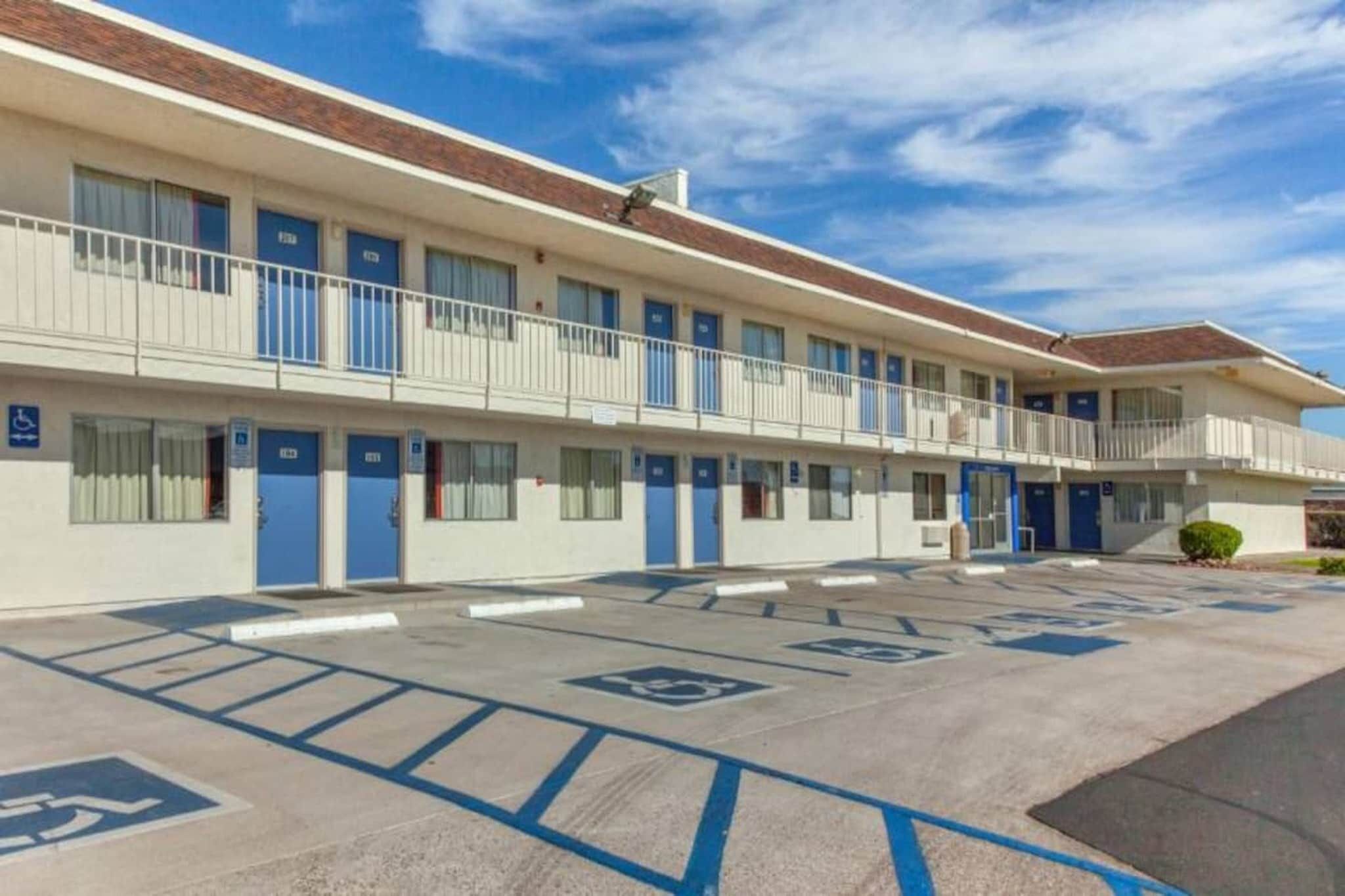 A motel with a parking lot marked with handicapped parking spaces.