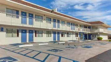 A motel with a parking lot marked with handicapped parking spaces.