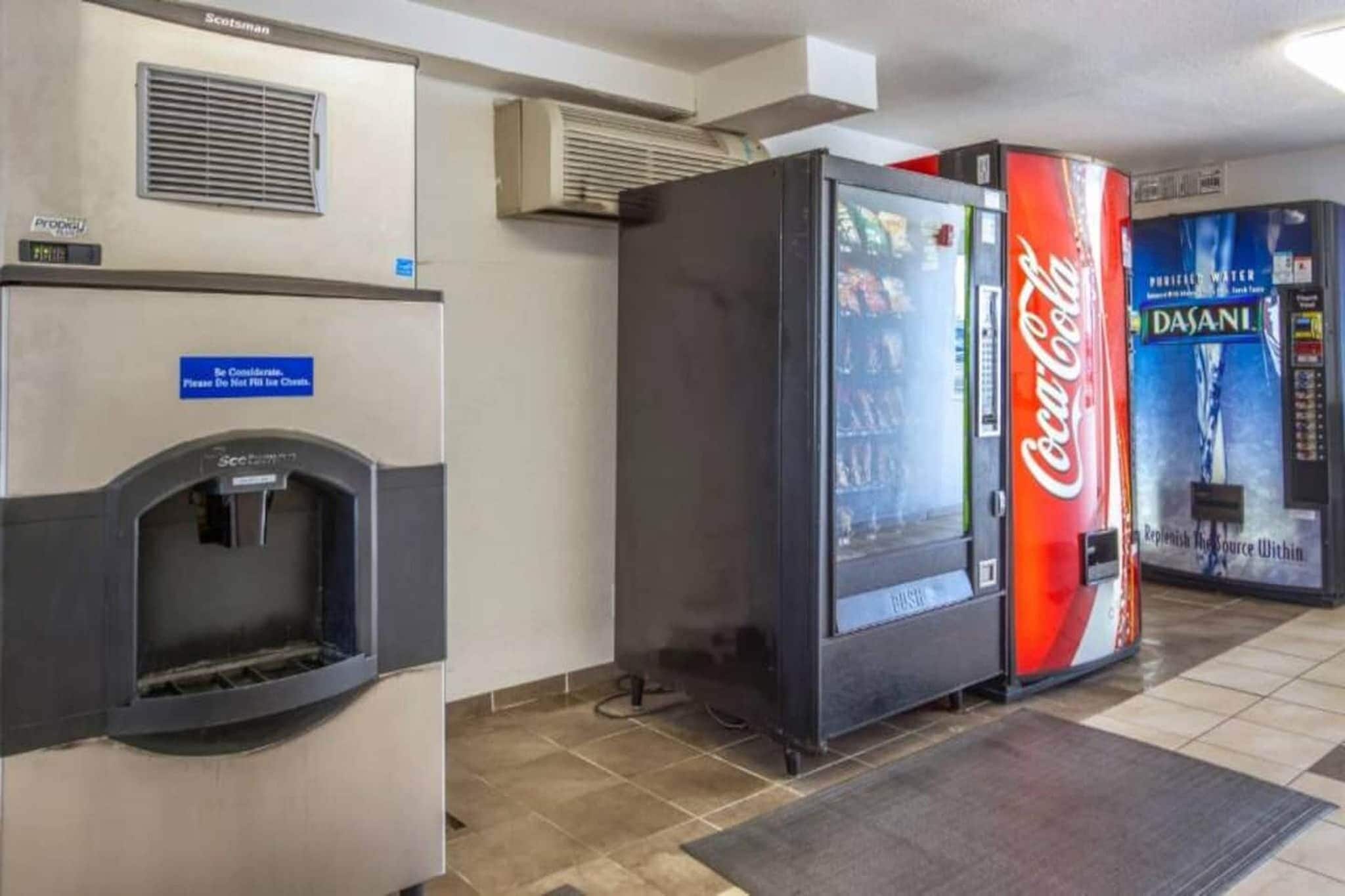 A vending area with a water dispenser and a Coca-Cola refrigerator.