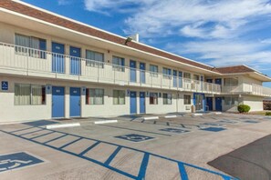 Un motel doté de nombreuses chambres, d’un parking avec des places réservées aux personnes handicapées et d’un ciel dégagé.