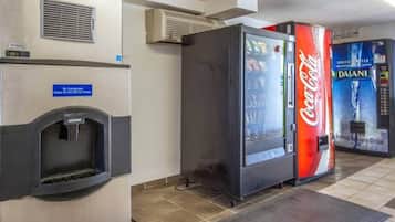 Un área de venta con un dispensador de agua y dos refrigeradores de Coca-Cola.