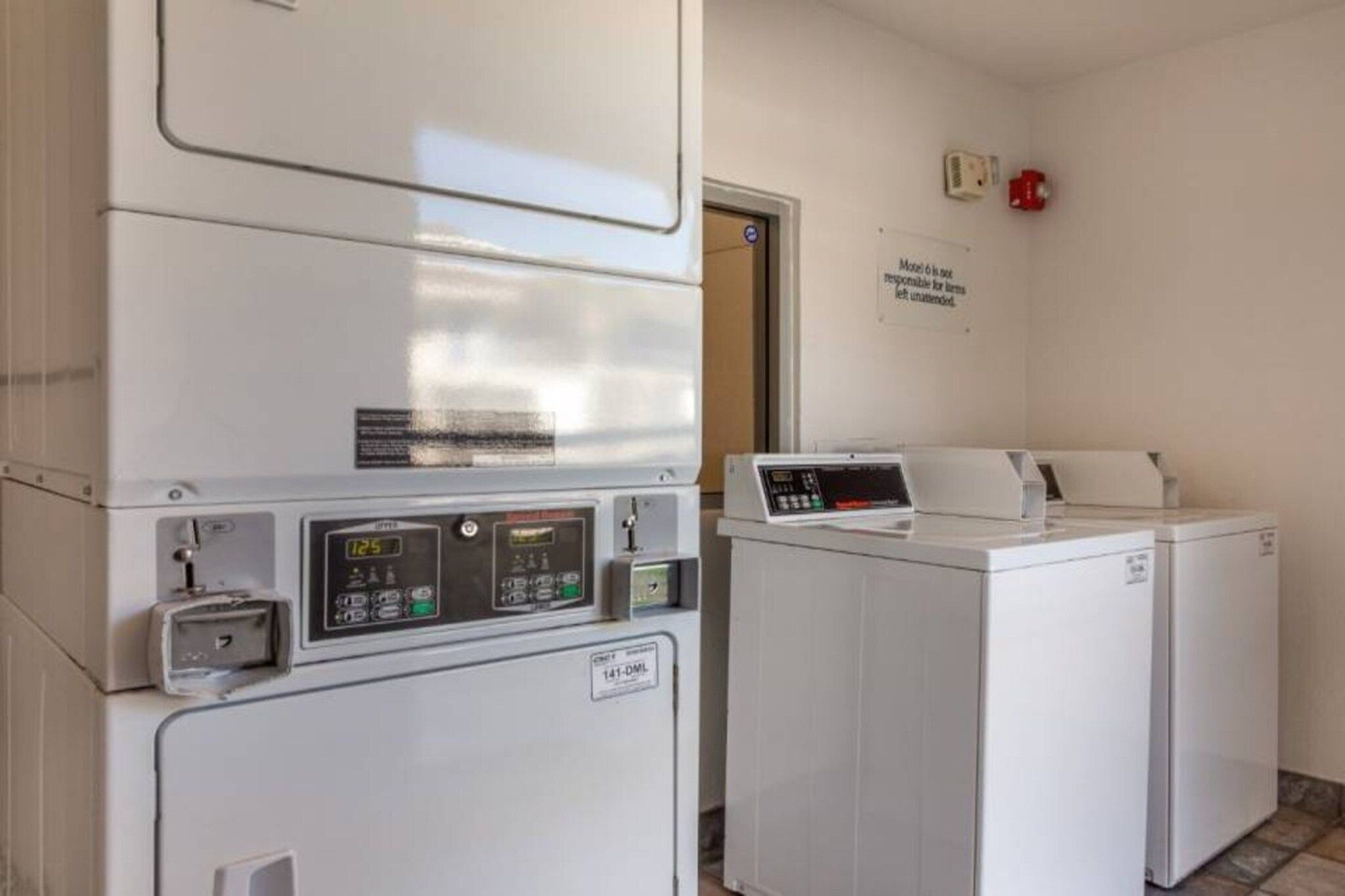 A laundry facility with a front-loading washing machine and a stacked dryer.