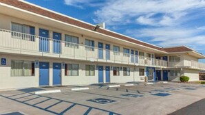 Um motel com estacionamento demarcado com vagas para deficientes.