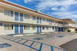 Un motel con un estacionamiento señalizado con espacios para discapacitados.