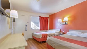 A hotel room with two beds, a desk, a window with curtains, and wall-mounted lamps. - 2 Full Beds | Premium (Phoenix)
