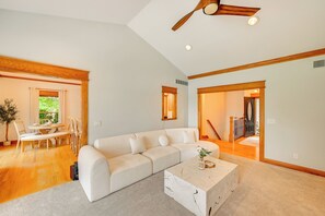 A spacious living area with a white sofa, a coffee table, and a dining area with a table and chairs. - St Joseph River Retreat w/ Private Pool (Mishawaka)