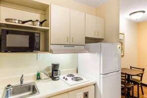 Une petite cuisine équipée d’un four à micro-ondes, d’une cuisinière et d’un réfrigérateur.