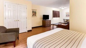 A hotel room with a bed, a chair, a desk, a television, and a wardrobe. - 1 Queen Bed | Mob Acc RI Shwr Nsmk Sofa (Myrtle Beach SC)