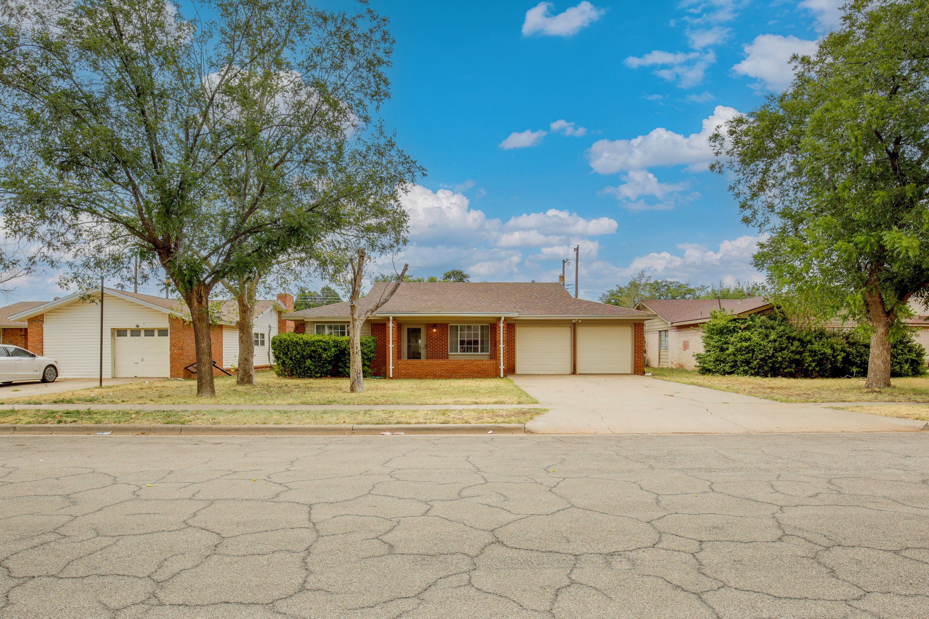 A residential house with a garage, a driveway, and a lawn.