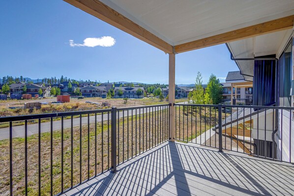 Un balcon donnant sur un quartier résidentiel, avec vue sur des maisons et une route.