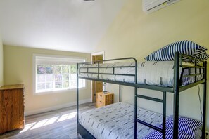 Habitació amb literes, una finestra, un escriptori i un petit tamboret.