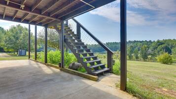 Una escalera cubierta al aire libre que da a una zona verde con vistas a árboles y un cielo despejado.