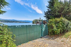 A fenced property with a view of a lake and mountains in the distance. - 1 Block to Private Key Entry Beach (Bellingham)