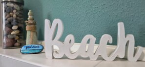 A decorative sign spelling 'Beach' with a small bottle labeled 'Graal-Mist' beside it. - KWU 10 OG Vacation Rental - "Coastal Oasis" - The Ultimate Vacation: Your Modern 4-Star (Gelbensande)