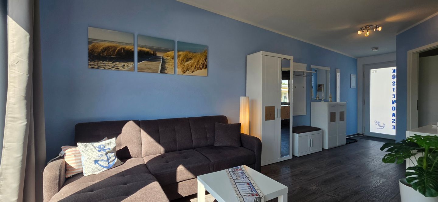 Ein Wohnzimmer mit einer Couch, einem Couchtisch und einem Gemälde an der Wand.