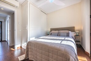A bedroom with a large bed, a ceiling fan, and a nightstand with a lamp. - Marbella gateway - 2BR House /w AC, Patio and Pool Surrounded by Golf Courses (Marbella)