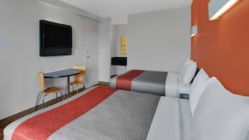 A hotel room with two beds, a desk, a chair, a television, and a wall-mounted control panel.