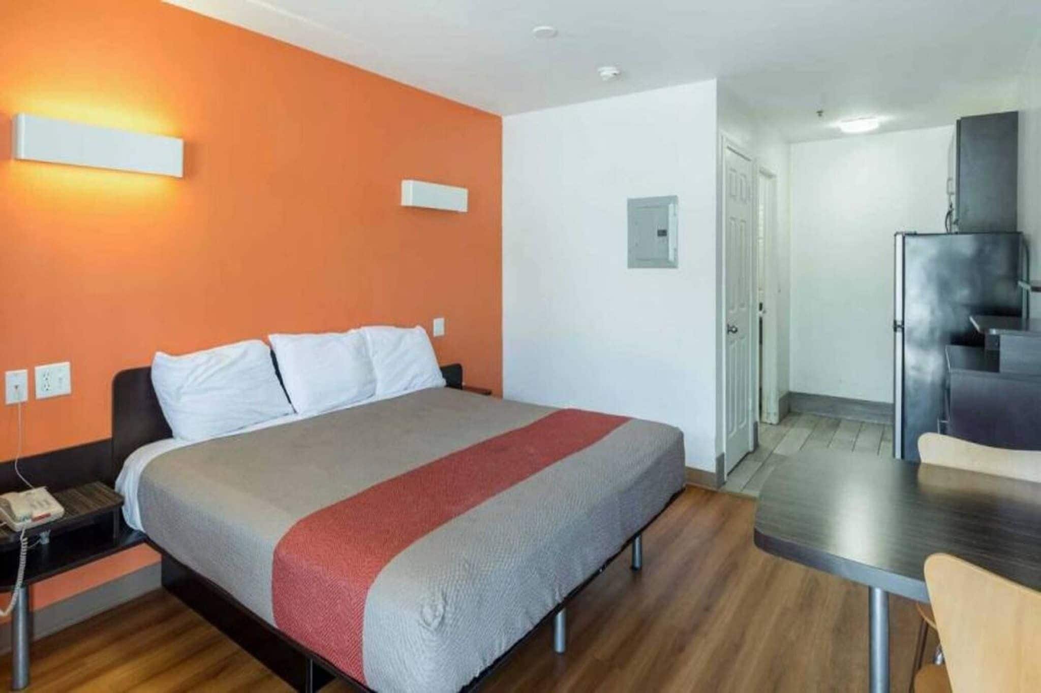 A hotel room with a bed, a desk, and a chair.