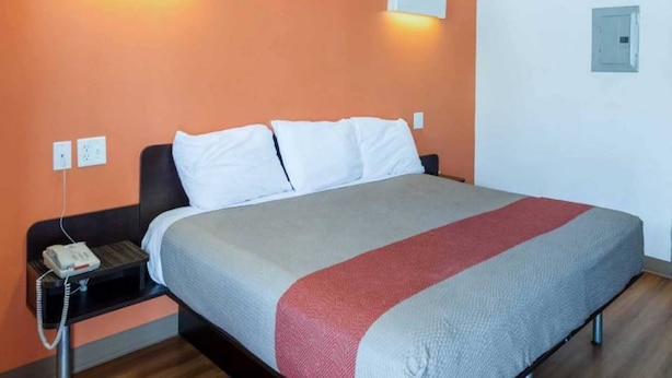 Ein Hotelzimmer mit einem Bett, einem Nachttisch und einem Telefon.
