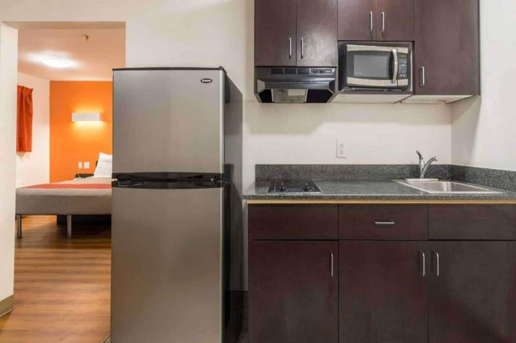 Eine kleine Küche mit Kühlschrank, Mikrowelle und Spüle.
