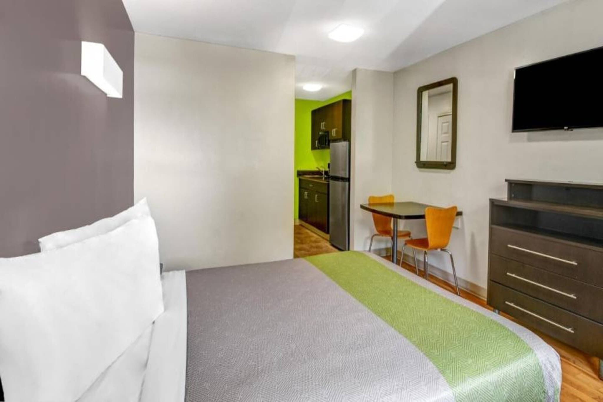 Une chambre d’hôtel équipée d’un lit, d’un bureau, d’une chaise, d’une télévision et d’une armoire.