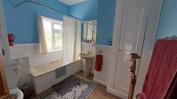 Une salle de bain avec une baignoire, un lavabo et des toilettes.