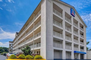 Un parking à étages avec un panneau bleu situé dans le coin supérieur droit.