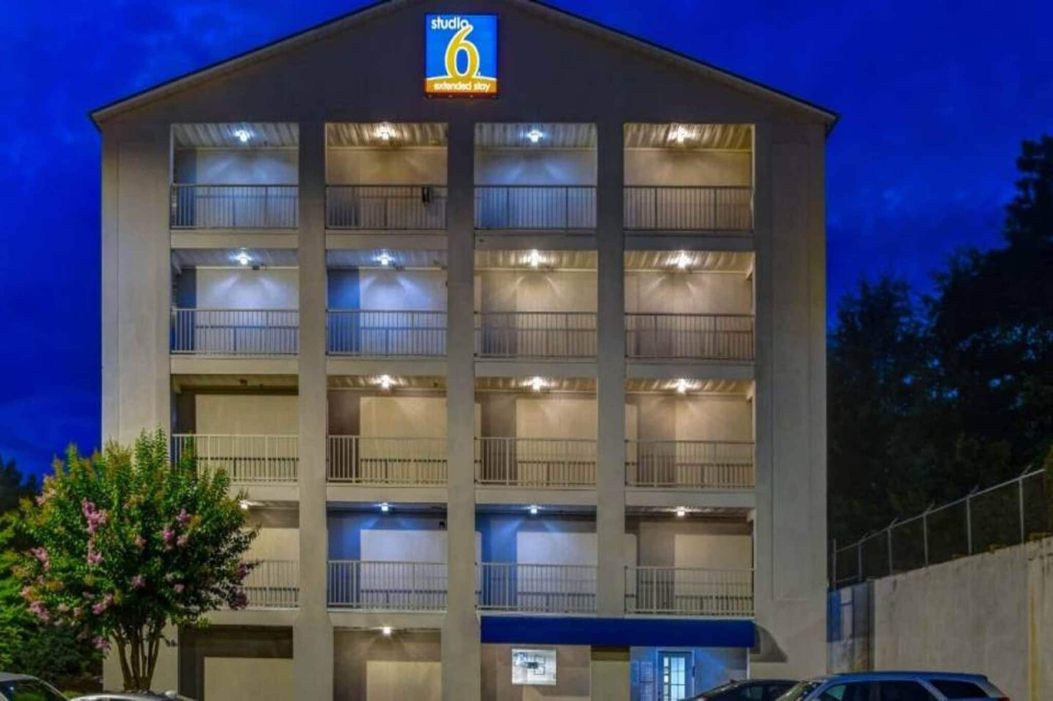 Un hotel de varios pisos con un letrero que indica que es un hotel Studio 6 para estancias prolongadas.