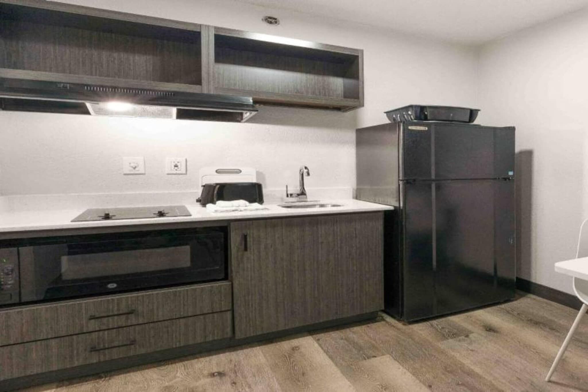 Una cocina equipada con horno empotrado, refrigerador y microondas.