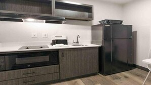 Una cocina equipada con horno empotrado, refrigerador y microondas.