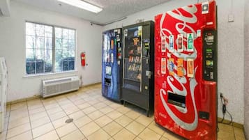 Une pièce avec une fenêtre, un radiateur et trois distributeurs automatiques.