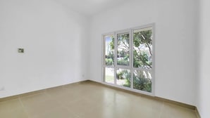 A room with a large window, white walls, and a tiled floor. - 5 bedroom villa with direct access to Montgomerie Golf - Perfect for families (Dubai)