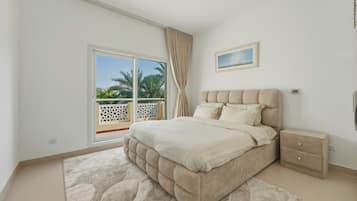 A bedroom with a bed, a nightstand, a window with a view, and a ceiling light.