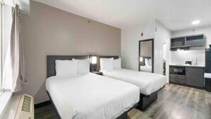 A hotel room with two beds, a kitchenette, and a bathroom. - 2 Queen Beds | Non-Smoking (Tucker)