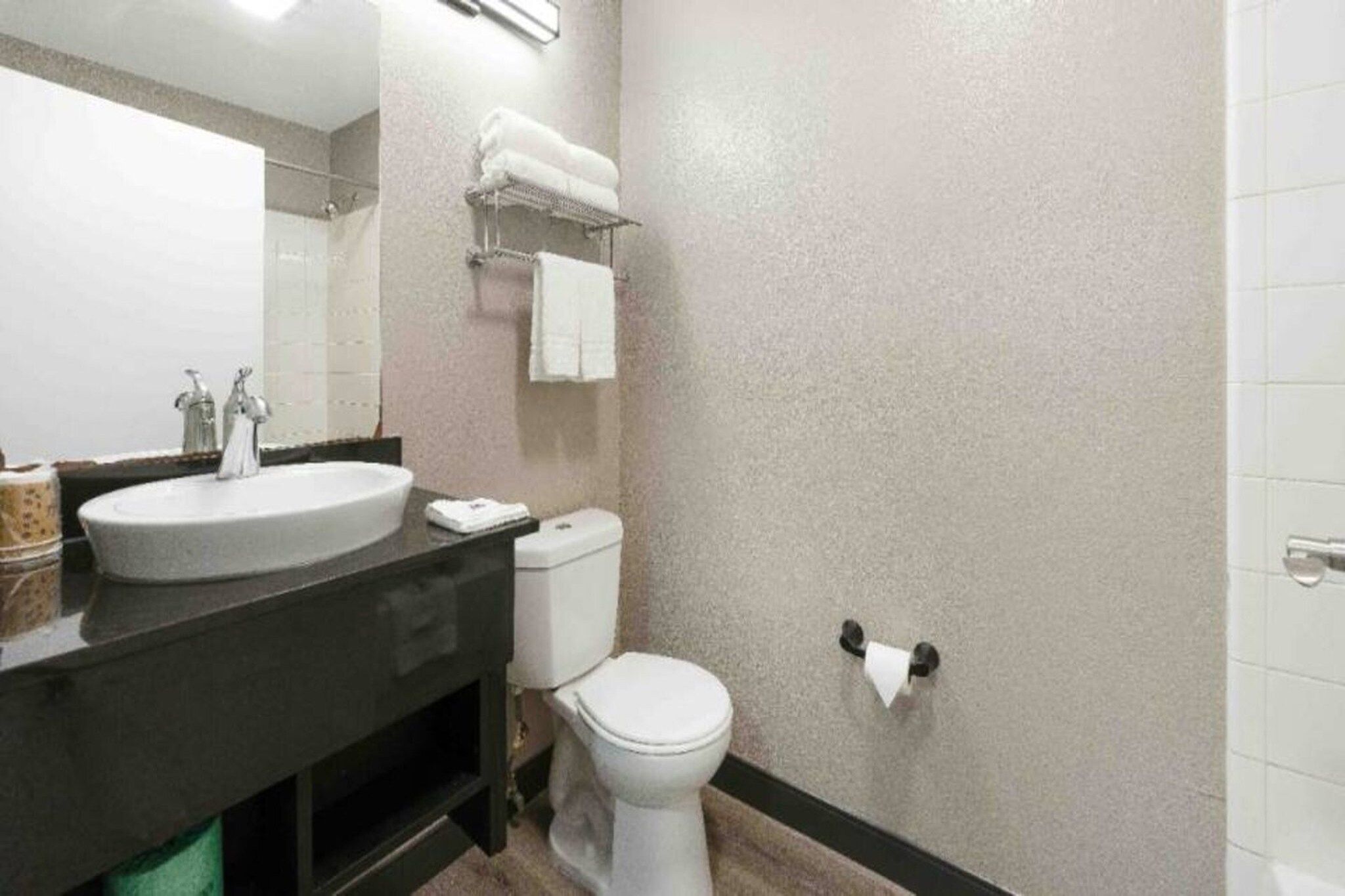 Un baño con lavamanos, inodoro y zona de ducha.