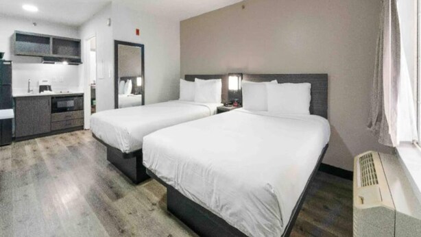 A hotel room with two beds, a kitchenette, and a bathroom. - 2 Queen Beds | Non-Smoking (Tucker)