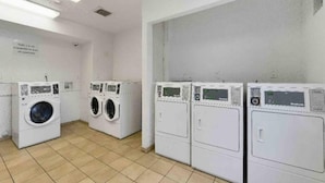 A laundry facility with four washing machines and a tiled floor. - 2 Beds | Smoking, Deluxe (Tucker)