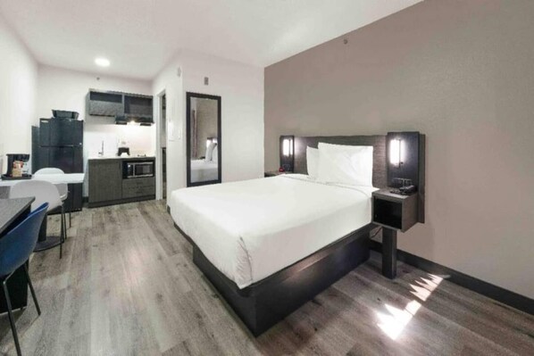 Ein Hotelzimmer mit einem Bett, einem Nachttisch und einem Schreibtisch mit Stuhl.