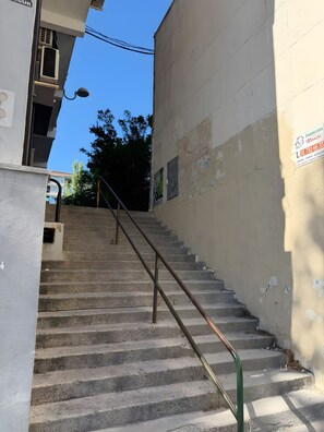 A concrete staircase with metal handrails leading up to a building entrance.