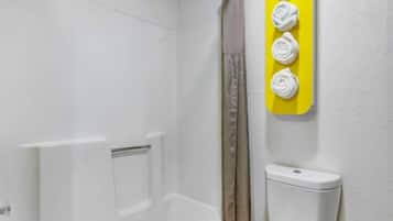 Un baño con una bañera blanca, un cortinero de ducha y un inodoro.