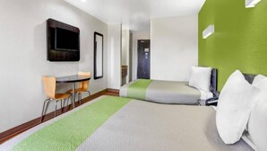 A hotel room with a bed, a desk, a chair, and a television. - 2 Queen Beds | Non-Smoking, Mini Fridge (Moriarty)