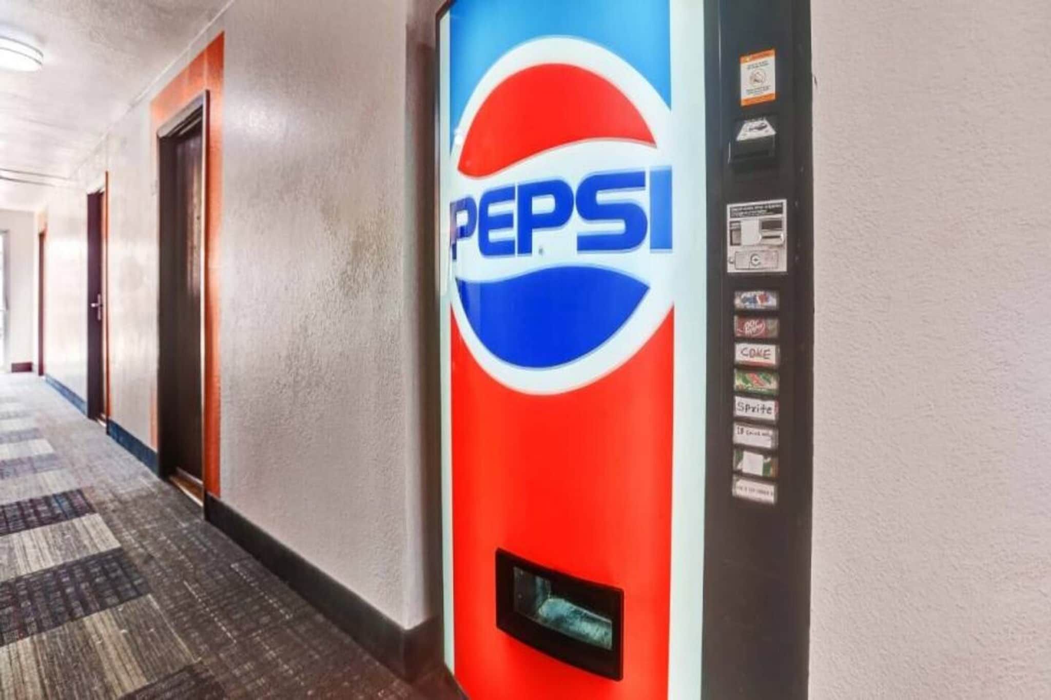 Un pasillo con una máquina expendedora que muestra el logotipo de Pepsi.