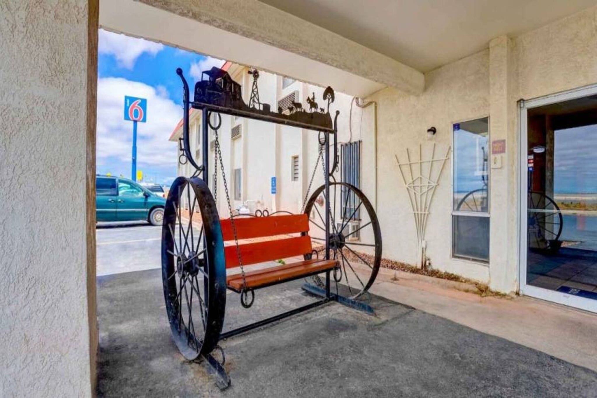 Un carruaje antiguo estacionado frente a un edificio, con un cielo despejado al fondo.