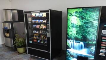 Máquina de vendas com lanches e uma tela de televisão exibindo uma cascata.