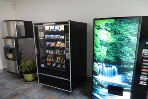 Ein Getränkeautomat mit Snacks und einem Fernsehbildschirm, der einen Wasserfall zeigt.