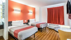 A hotel room with two beds, a desk, a chair, and a red curtain. - 2 Full Beds | Non-Smoking (Harvey)