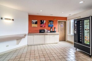 A reception area with a counter, a microwave, and a refrigerator.