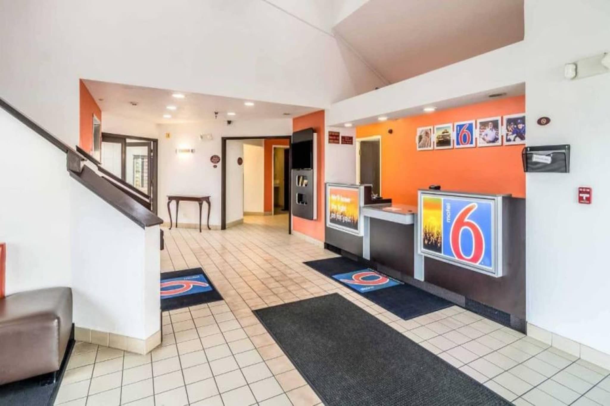Ein Hotel-Empfangsbereich mit einer Rezeption, einer Treppe und einem an der Wand befestigten Schild.